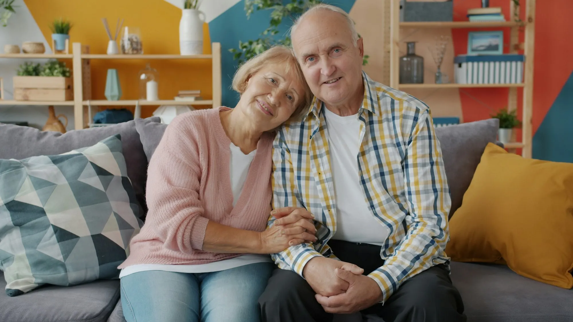 An older couple sitting together on a sofa