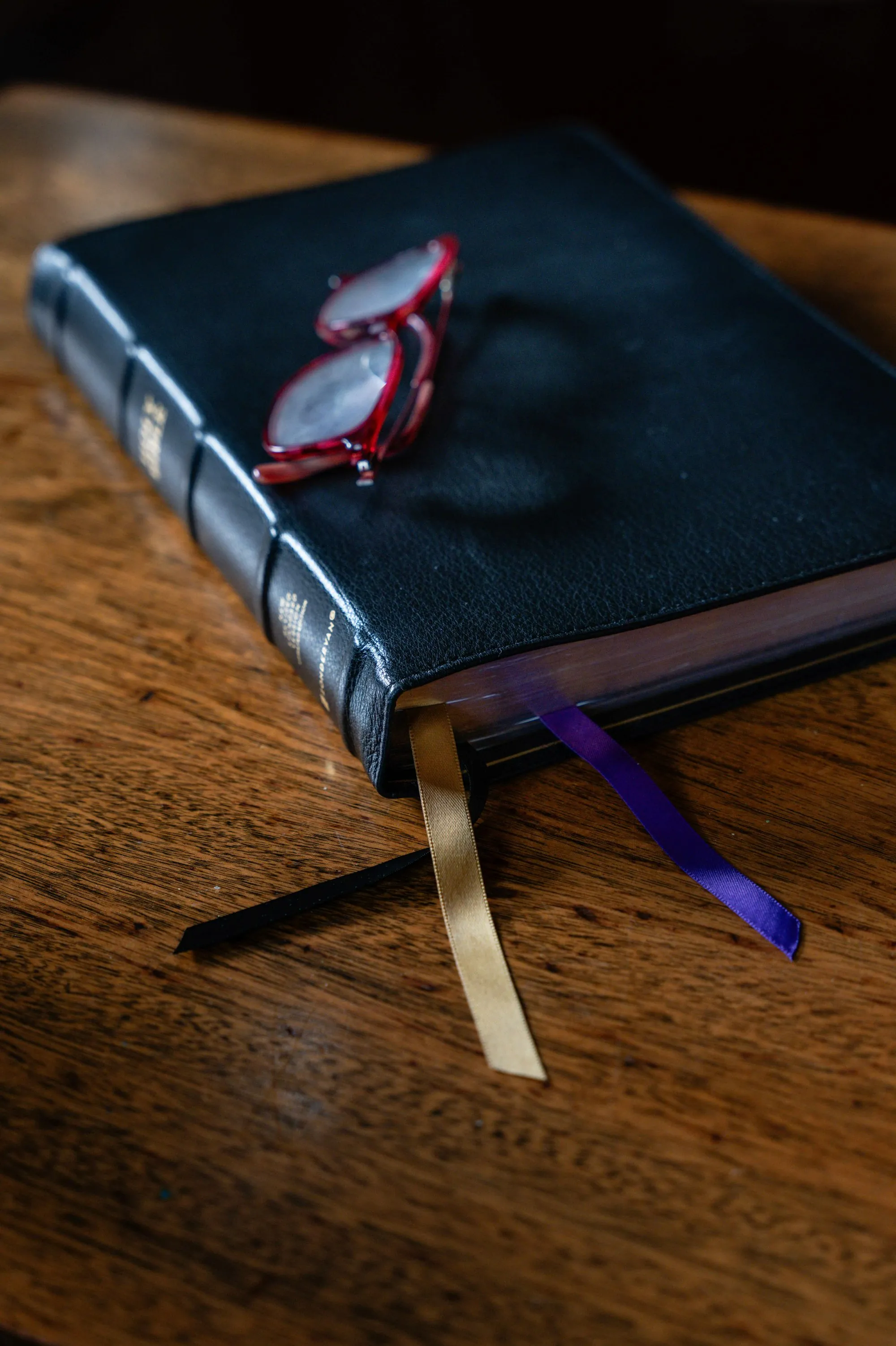 A closed book with a pair of reading glasses on top