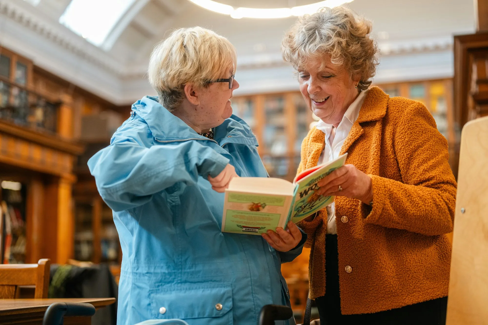 Two women looking through a book together